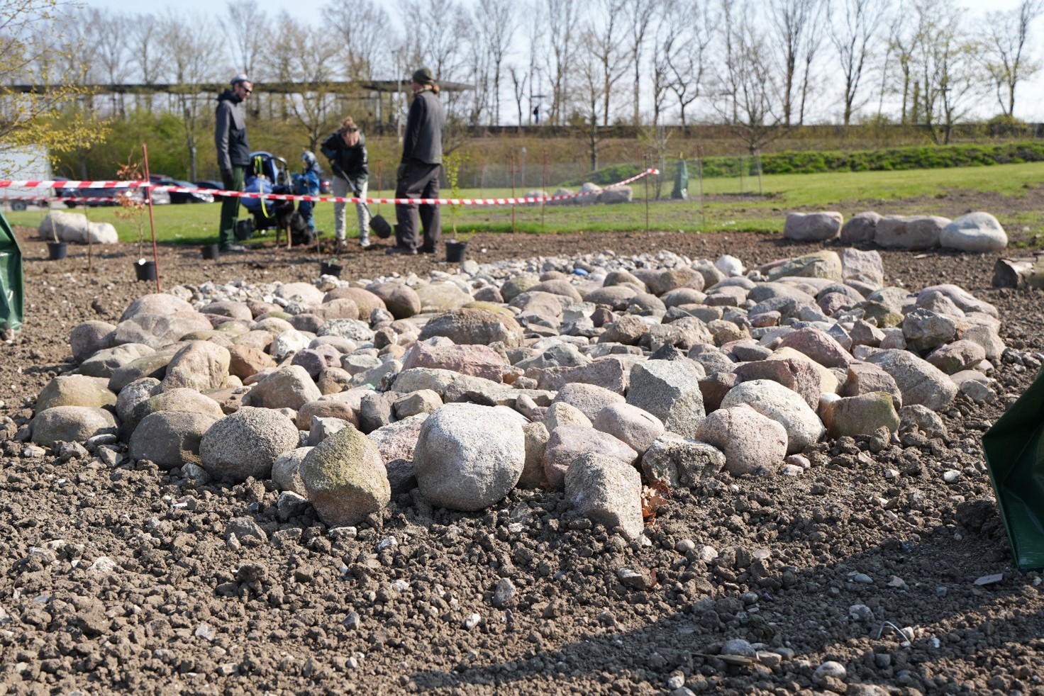 Natursten i Brøndby Strand Naturhave, med personer der graver i baggrunden