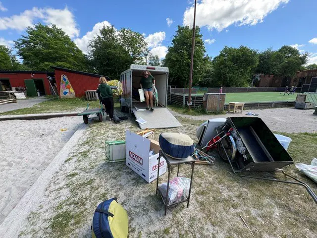 Personale forbereder brugte møbler på græsplane til Albertslund Børnefestuge
