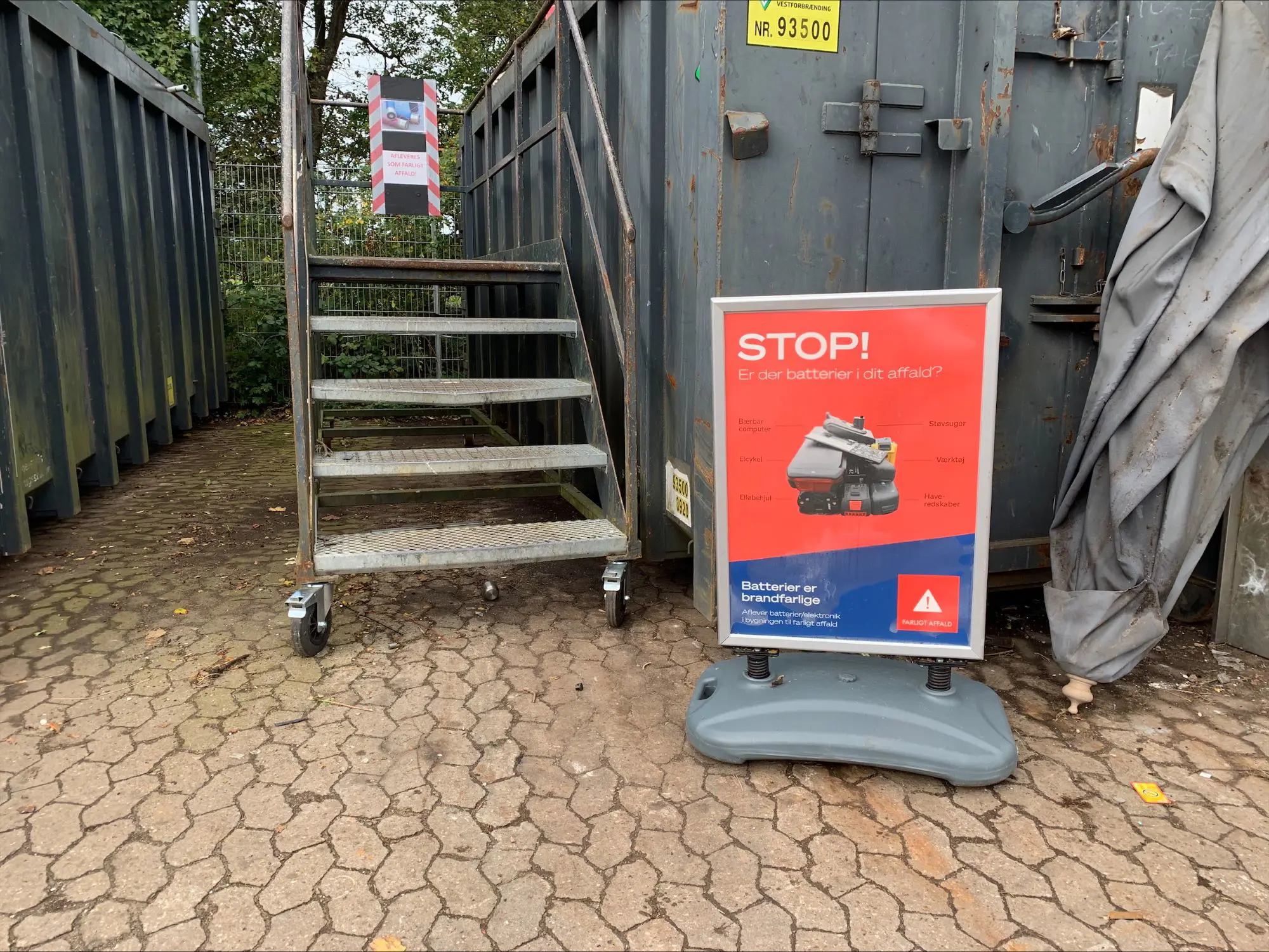 Plakat om sortering af affald med batterier på genbrugsstationen