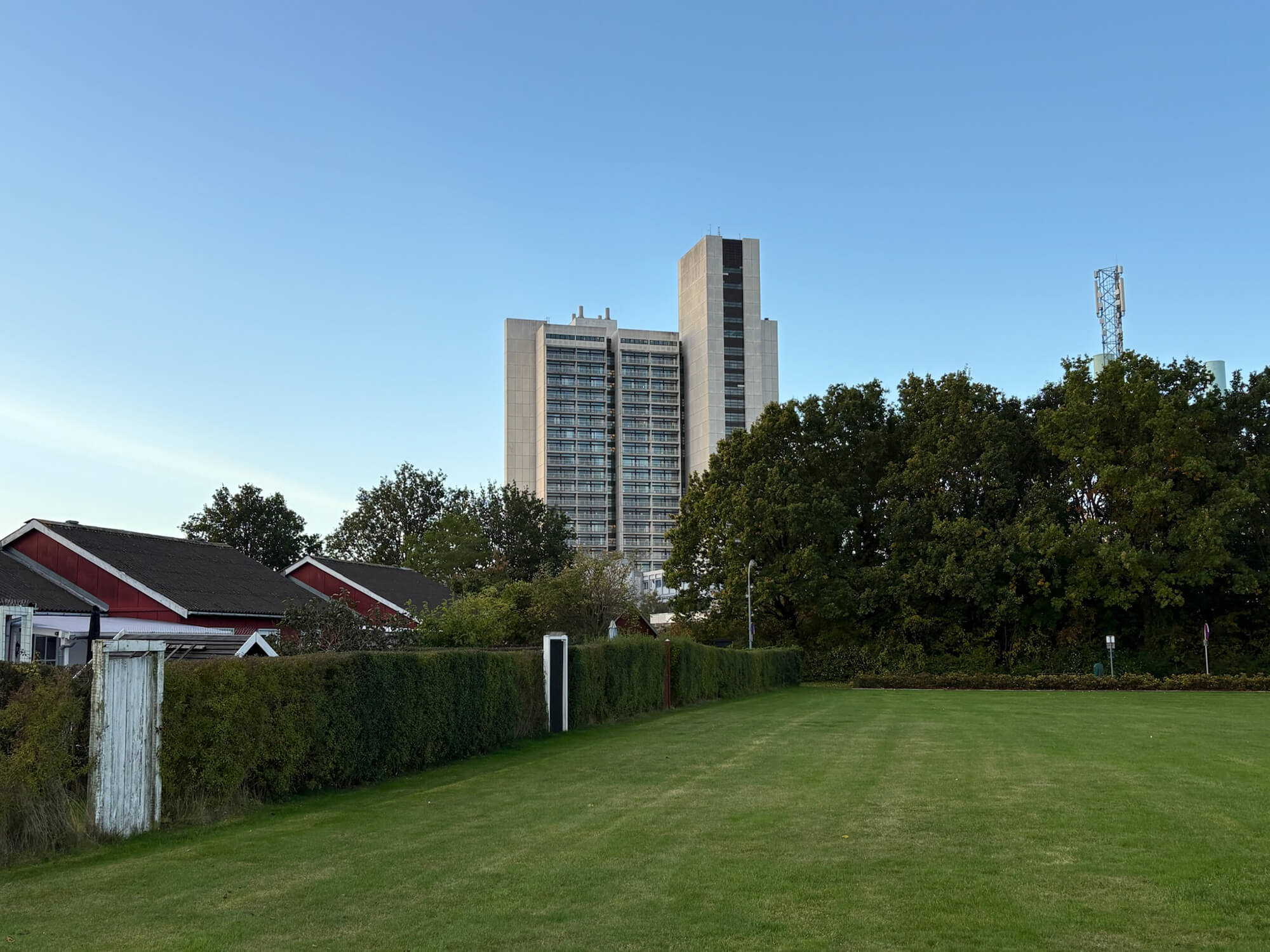 Stor græsplæne med huse i siden og Herlev Hospital i baggrunden